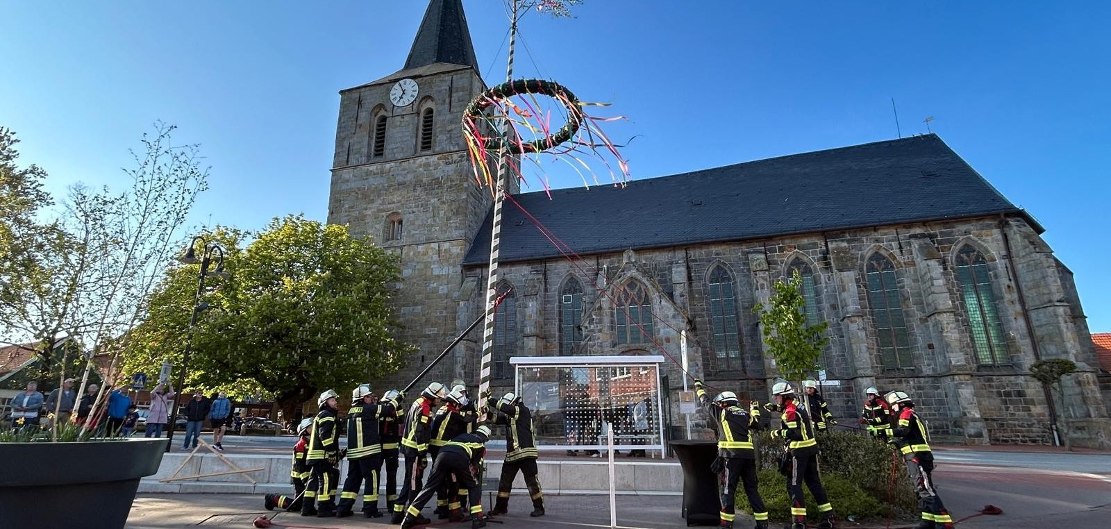 Meiboomoprichting 2026 - de meiboom staat, kerk op de achtergrond