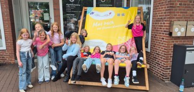 Eine Gruppe Mädchen macht ein Gruppenfoto vor Marken am Markt